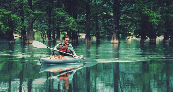 男は湖でカヤックで漕ぐ — ストック写真