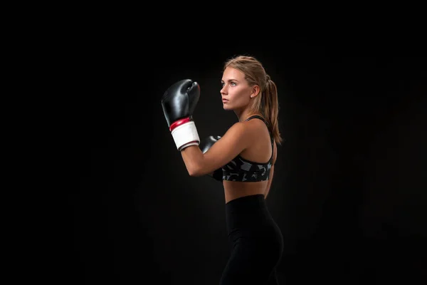美丽的女运动员在拳击手套 在演播室在黑背景 — 图库照片