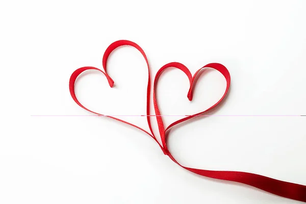 Δύο Καρδιές Δεμένα Μαζί Κατασκευασμένα Από Κόκκινη Κορδέλα — Φωτογραφία Αρχείου