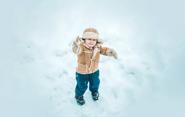冬の子供の雪の屋外で幸せ 冬服のかわいい男の子 テーマクリスマス休暇と新年 — ストック写真