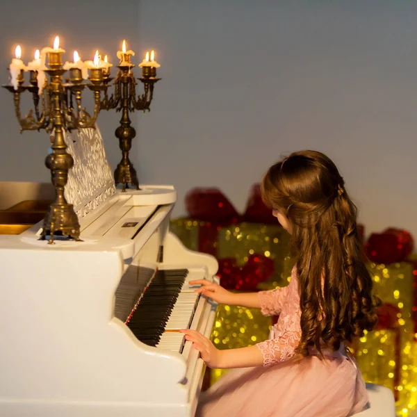 Девочка Играет Пианино Смотрит Горящие Свечи — стоковое фото