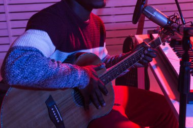 Afrikalı Amerikalı profesyonel müzisyen dijital stüdyoda gitar kaydediyordu. Müzik prodüksiyon teknolojisi konsepti, yakın çekim..
