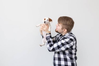 insanlar, Evcil hayvanlar ve hayvanlar kavramı - genç adam tutarak jack russell terrier yavru beyaz arka plan üzerinde