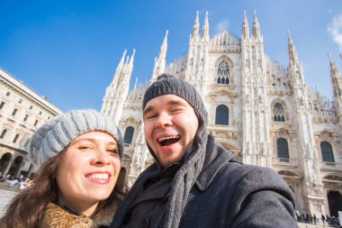 Milano Duomo Meydanı'nda kendi kendine portre çekici çift. Seyahat ve ilişki kavramı