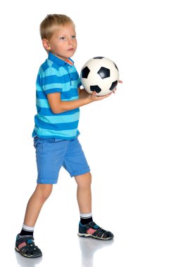 Küçük çocuk bir futbol topuyla oynuyor.