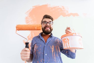 Duvarı boyayan komik adam. Yenileme, dekorasyon ve onarım konsepti.