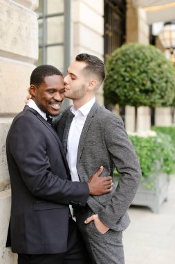 Afro-Amerikalı gay dışarıda Avrupalı adamı kucaklıyor.