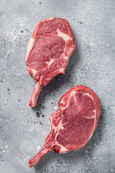 肉屋のテーブルの上に生のトマホークビーフ ステーキ 灰色の背景 トップ表示 — ストック写真
