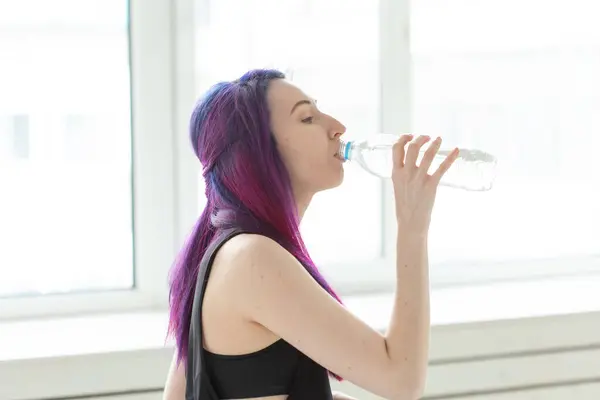 色付きの髪を持つ若い女の子のヒップスターは ジムで激しい身体トレーニングの後 ボトルから水を飲みます 体の渇きと水分バランスの概念 — ストック写真