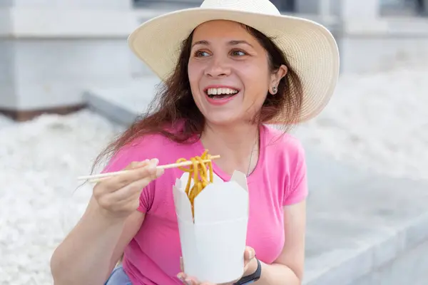 Ragazza Positiva Giovane Cappello Mangia Tagliatelle Cinesi Con Bacchette Legno — Foto Stock