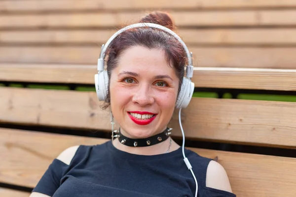 Portret Pięknej Stylowej Młodej Kobiety Słuchawkach Siedzących Parku Ciepłym Letnim — Zdjęcie stockowe