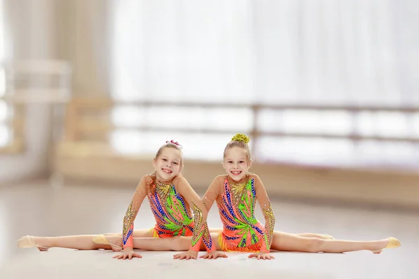 坐在分裂的两个女孩体操运动员 — 图库照片