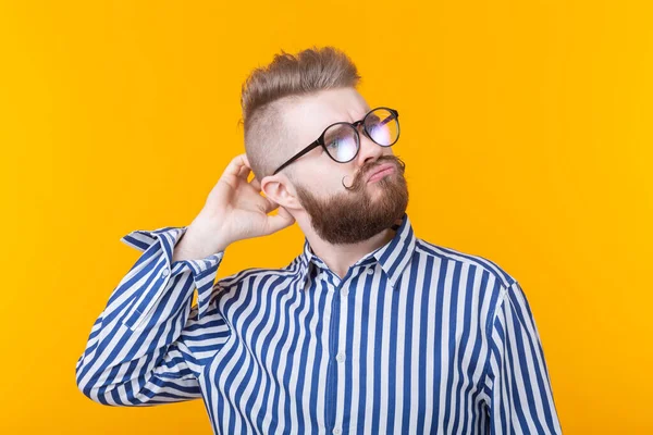 Sakallı Gözlüklü Sevimli Zeki Genç Adam Sarı Bir Arka Plan — Stok fotoğraf