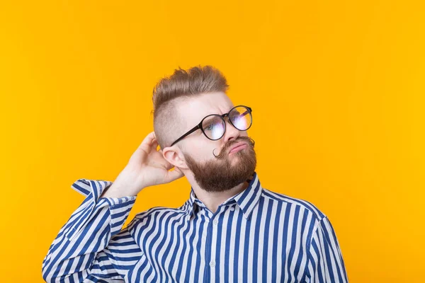 Jovem Inteligente Bonito Com Barba Óculos Posa Fundo Amarelo Pensa — Fotografia de Stock