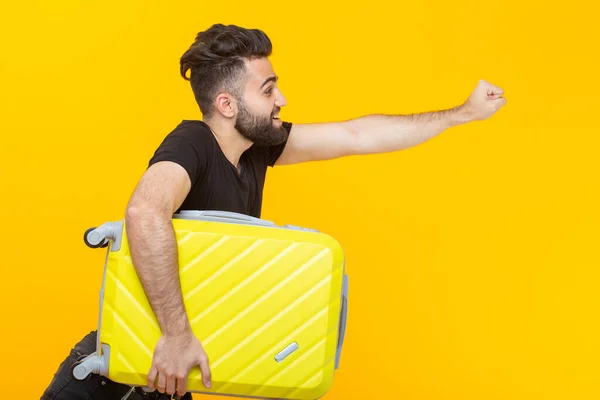 Sarı Bir Arka Plan Üzerinde Sarı Bir Bavul Tutan Bir — Stok fotoğraf