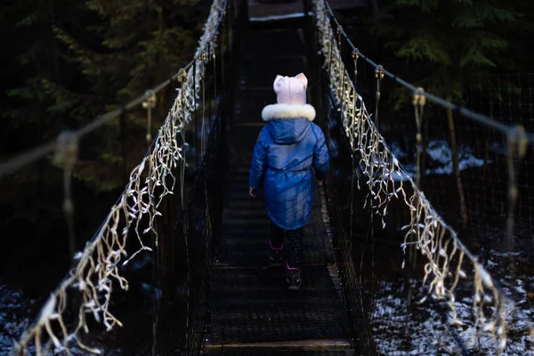 Klein Meisje Hangbrug Avond Tussen Kerstverlichting — Stockfoto