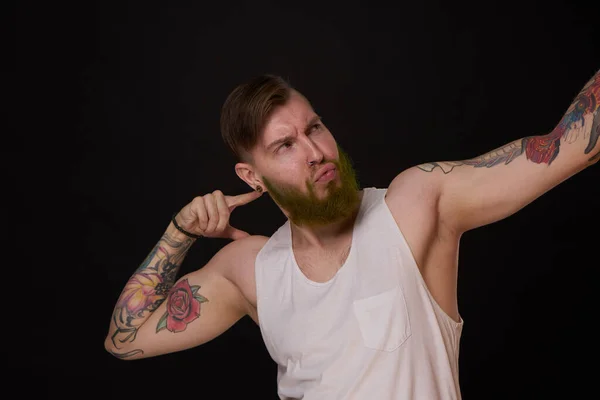 Vousatý Muž Tetováním Pažích Gestikuluje Rukama Tmavým Pozadím — Stock fotografie