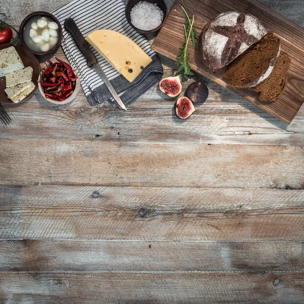 木のテーブルの上のチーズと黒パン — ストック写真
