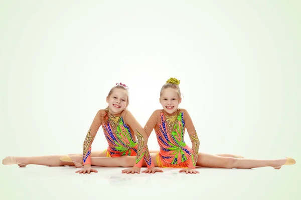 坐在分裂的两个女孩体操运动员 — 图库照片
