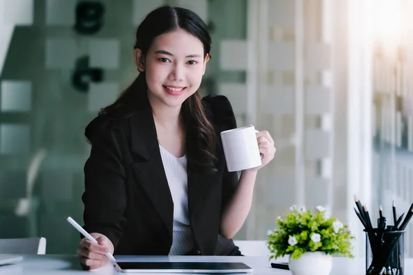 女性营销经理在使用平板电脑和营销分析论文之前 一边工作一边喝咖啡 一边减少睡意 — 图库照片
