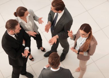 Üst Manzara. Bir grup çalışan ofiste konuşuyor.