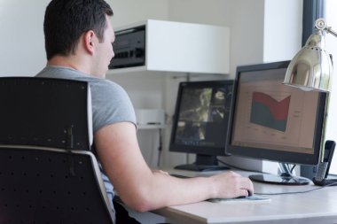 Delikanlı evde bilgisayarını tamir ediyor.