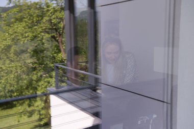 Erkek ve kadın çalışıyor, pencerenin dışını görüyor.