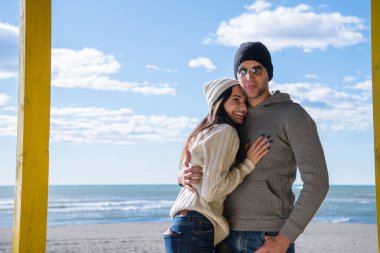 Çiftler konuşuyor ve sahilde eğleniyorlar.