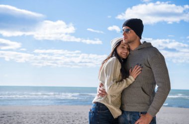 Çiftler konuşuyor ve sahilde eğleniyorlar.