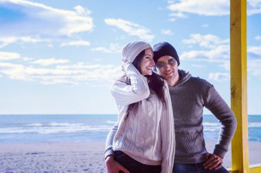 Çiftler konuşuyor ve sahilde eğleniyorlar.