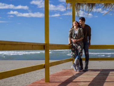 Çiftler konuşuyor ve sahilde eğleniyorlar.