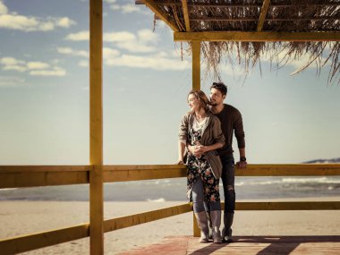 Çiftler konuşuyor ve sahilde eğleniyorlar.