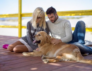 Köpekli çift sahilde eğleniyor.