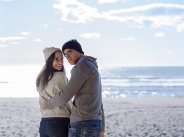 Çiftler konuşuyor ve sahilde eğleniyorlar.
