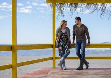 Çiftler konuşuyor ve sahilde eğleniyorlar.