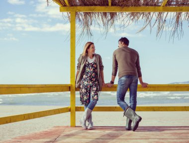 Çiftler konuşuyor ve sahilde eğleniyorlar.