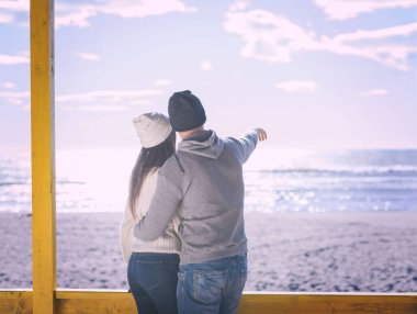 Çiftler konuşuyor ve sahilde eğleniyorlar.