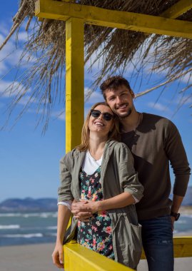 Çiftler konuşuyor ve sahilde eğleniyorlar.