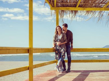 Çiftler konuşuyor ve sahilde eğleniyorlar.