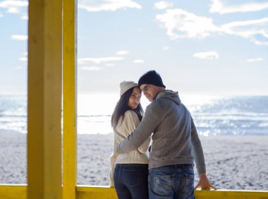 Çiftler konuşuyor ve sahilde eğleniyorlar.