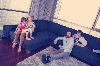 kanepede birlikte oynayan genç aile