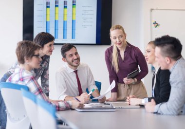 Genç iş adamları modern ofiste toplanıyor.