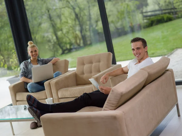 stock image couple relaxing at  home with tablet and laptop computers