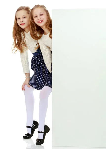 Zwei Kleine Mädchen Gucken Hinter Einem Weißen Werbeverbot Hervor — Stockfoto