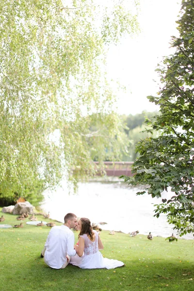 Young Caucasian Couple Sittling Lake Grass Kissing — Stock Photo, Image