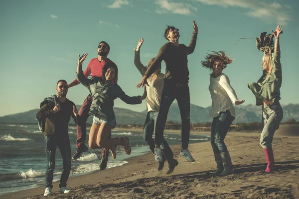 Jóvenes Amigos Saltando Juntos Playa Otoño — Foto de Stock