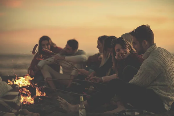 ビーチで火のそばに座っている若い友達のグループ — ストック写真