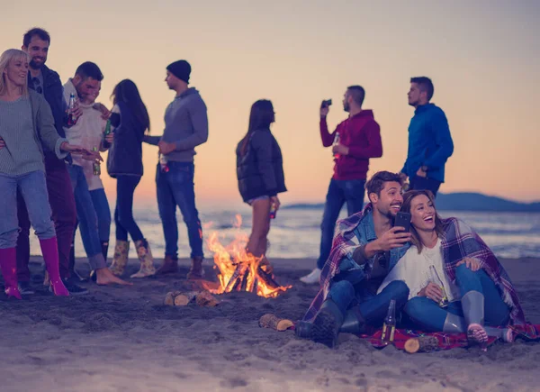 Pareja Disfrutando Hoguera Con Amigos Playa —  Fotos de Stock