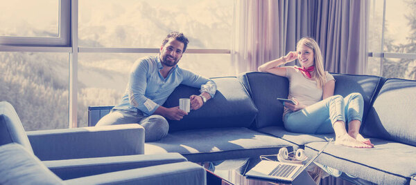 "couple relaxing at  home using tablet computer"