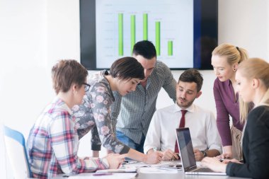 Genç iş adamları modern ofiste toplanıyor.